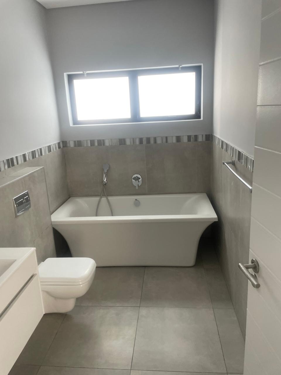 Bathroom bath area with tiled wall finish
