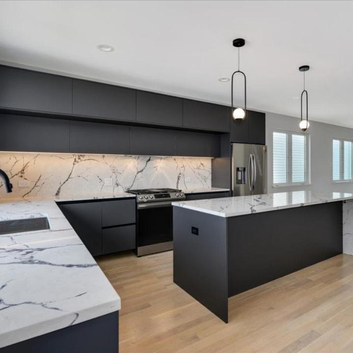 Modern kitchen renovation with dark cabinetry and stone counters