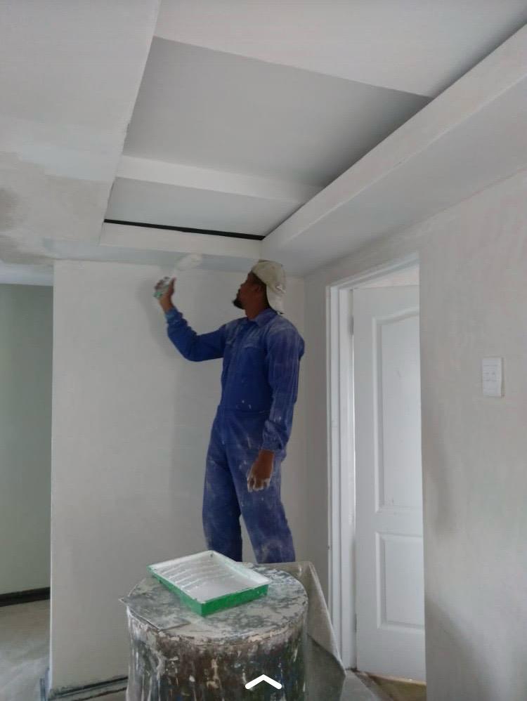 Dlazikare team member painting an interior wall