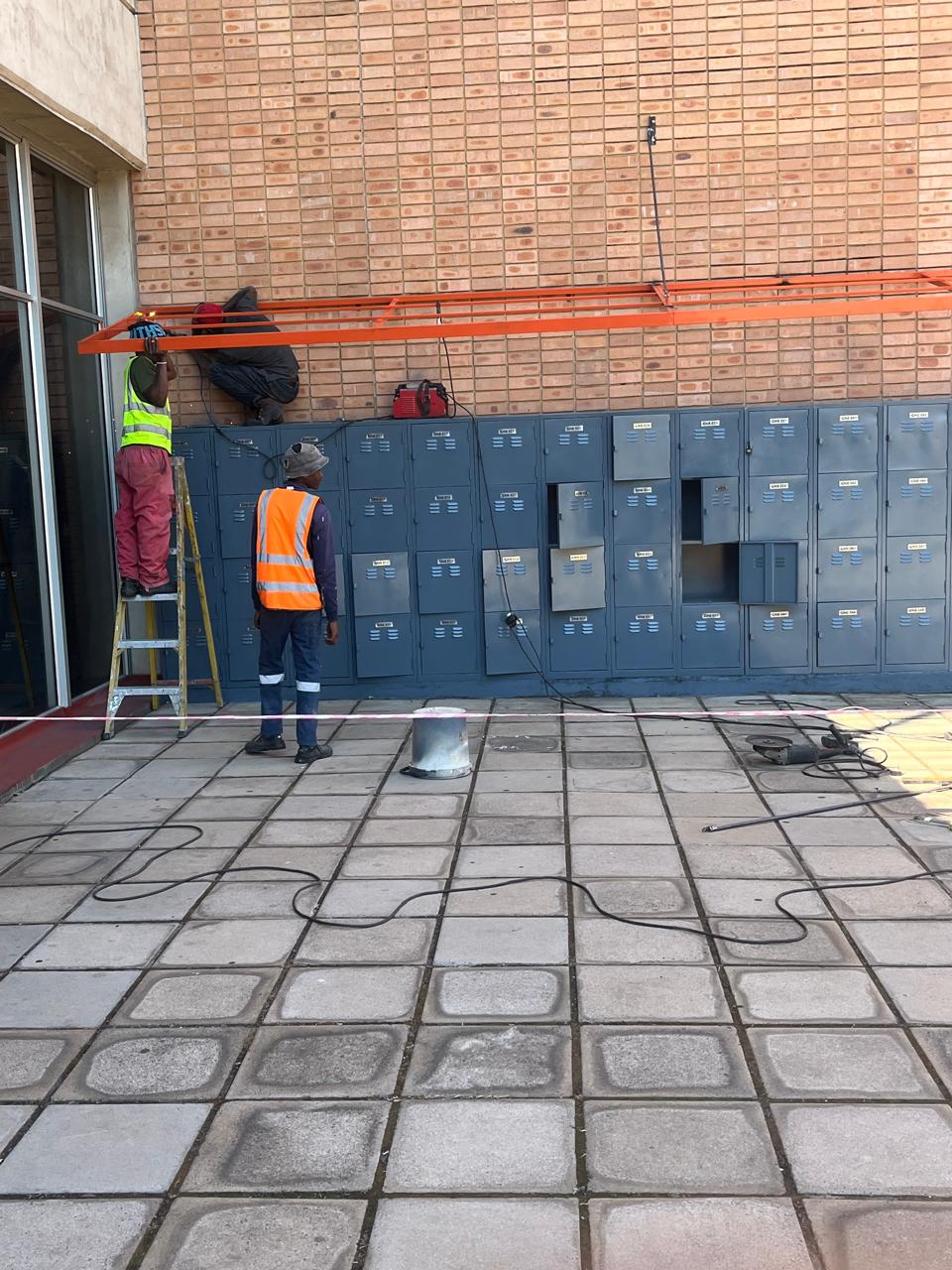 Team installing exterior building work above lockers